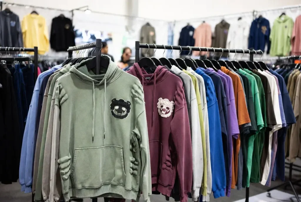  streetwear garments with puff printing, acid wash, and embroidery at a Canton Fair-style booth – highlights the exact techniques buyers evaluate on-site.