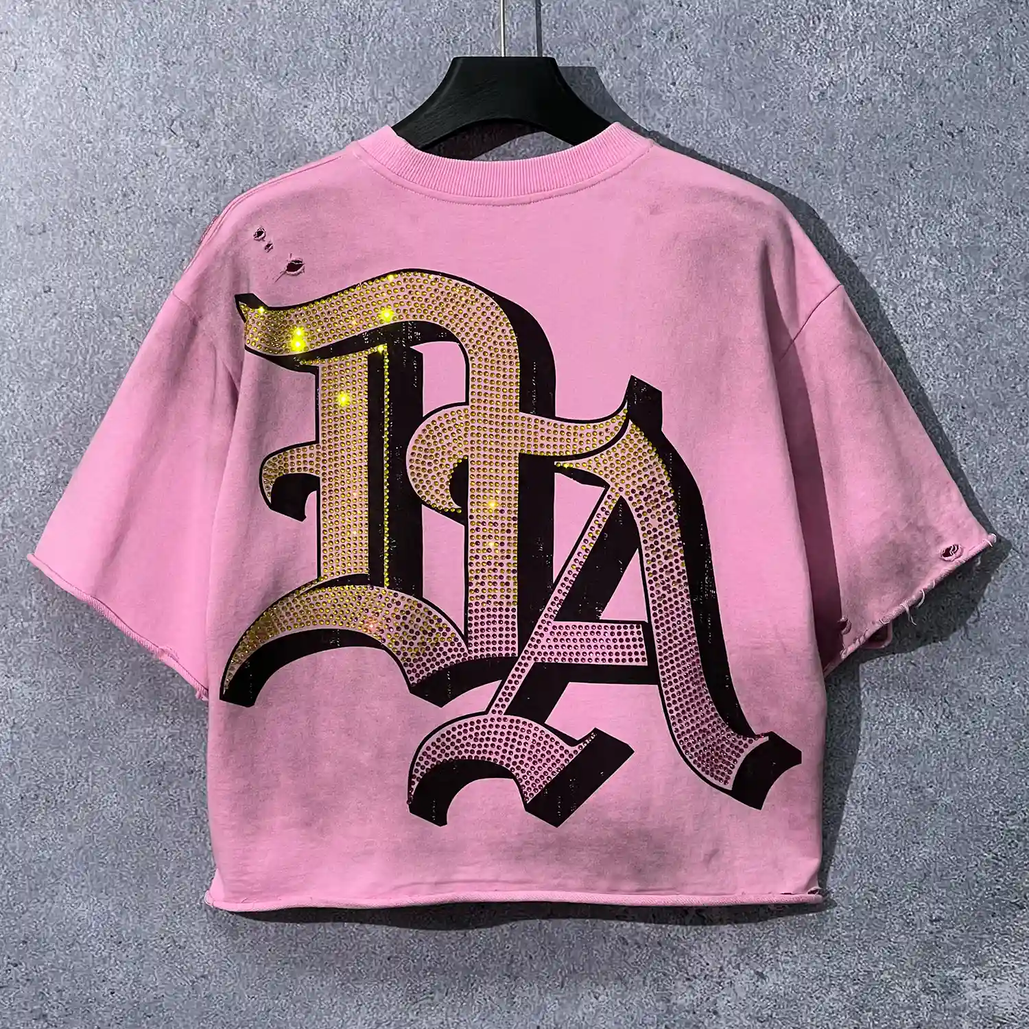 Back view of custom rhinestone distressed t-shirt with large gothic rhinestone letter detailing.